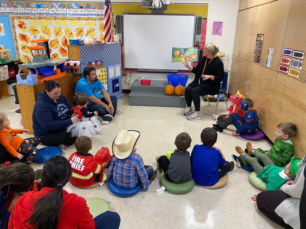 A group of childern sitting in a circle for story time